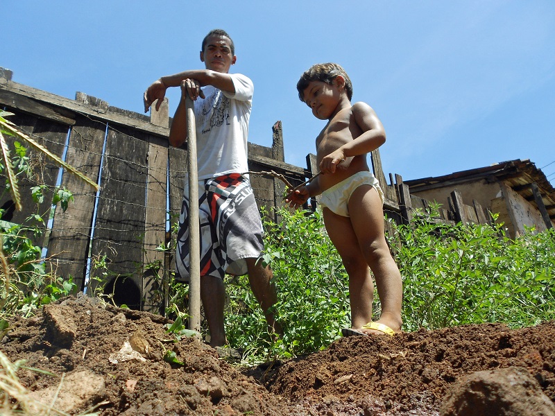 Nos momentos de folga, o jovem operário ajuda em serviços domésticos como abrir a vala do esgoto dos vizinhos. As casas não têm saneamento e, por isso, despejam seu esgoto nas ruas de terra batida. Foto: Fabíola Ortiz/O Eco