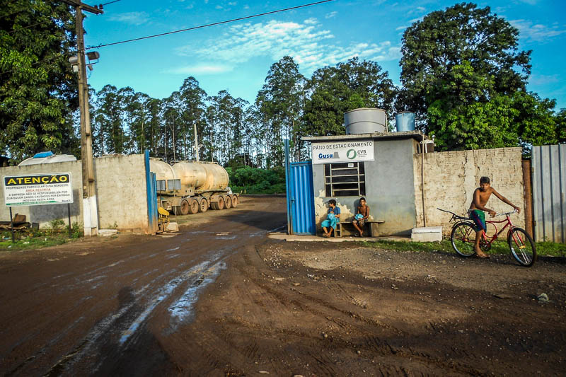 Crianças brincam no portão de entrada do pátio de estacionamento de caminhões e veículos pesados na beira de BR-222. Foto: Fabíola Ortiz/O Eco
