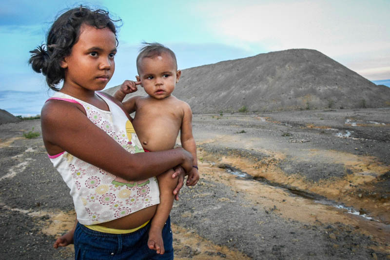 Crianças circulam diariamente pelo depósito a céu aberto de material químico para fabricar o cimento. O terreno fica ao lado das casas de moradores. Foto: Fabíola Ortiz/O Eco