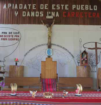 “Tenha piedade deste povo e lhes dá uma estrada” diz o cartaz que faz parte de uma campanha de religioso local pela estrada. Crédito: Global Witness Report