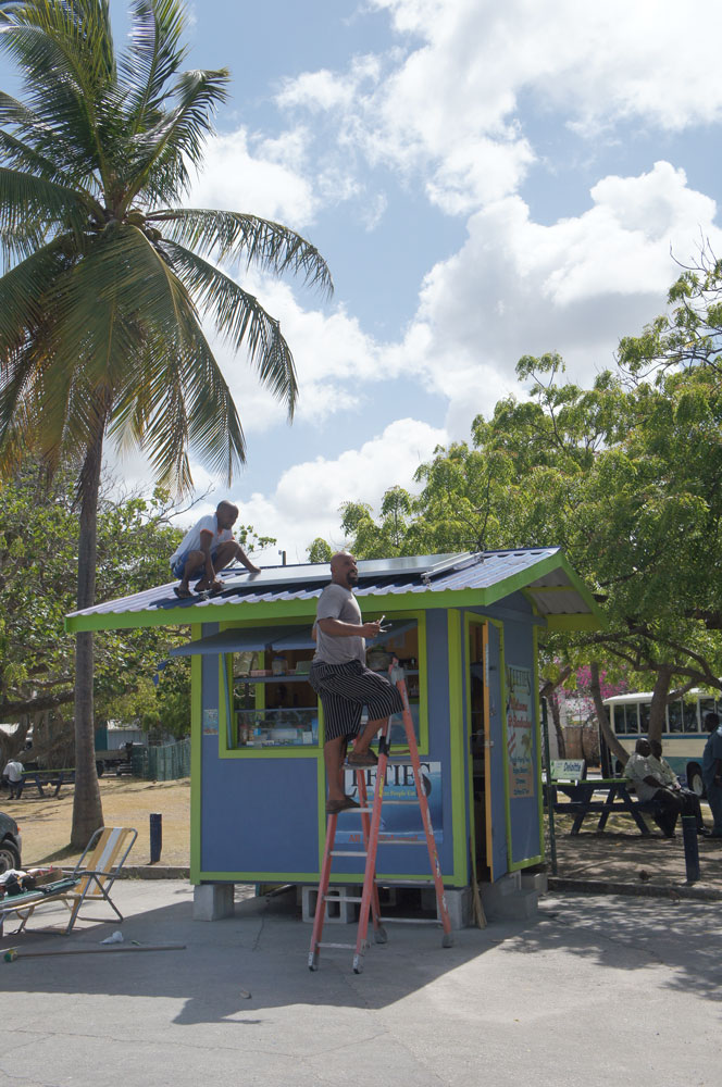 Um pequeno comerciante de praia instala um painel solar.